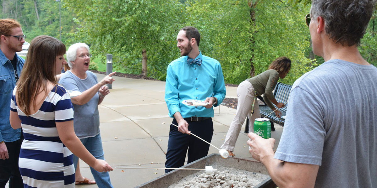 Communications Department members listen to Paula Bennett, associate professor of broadcast media, during a fall cookout.